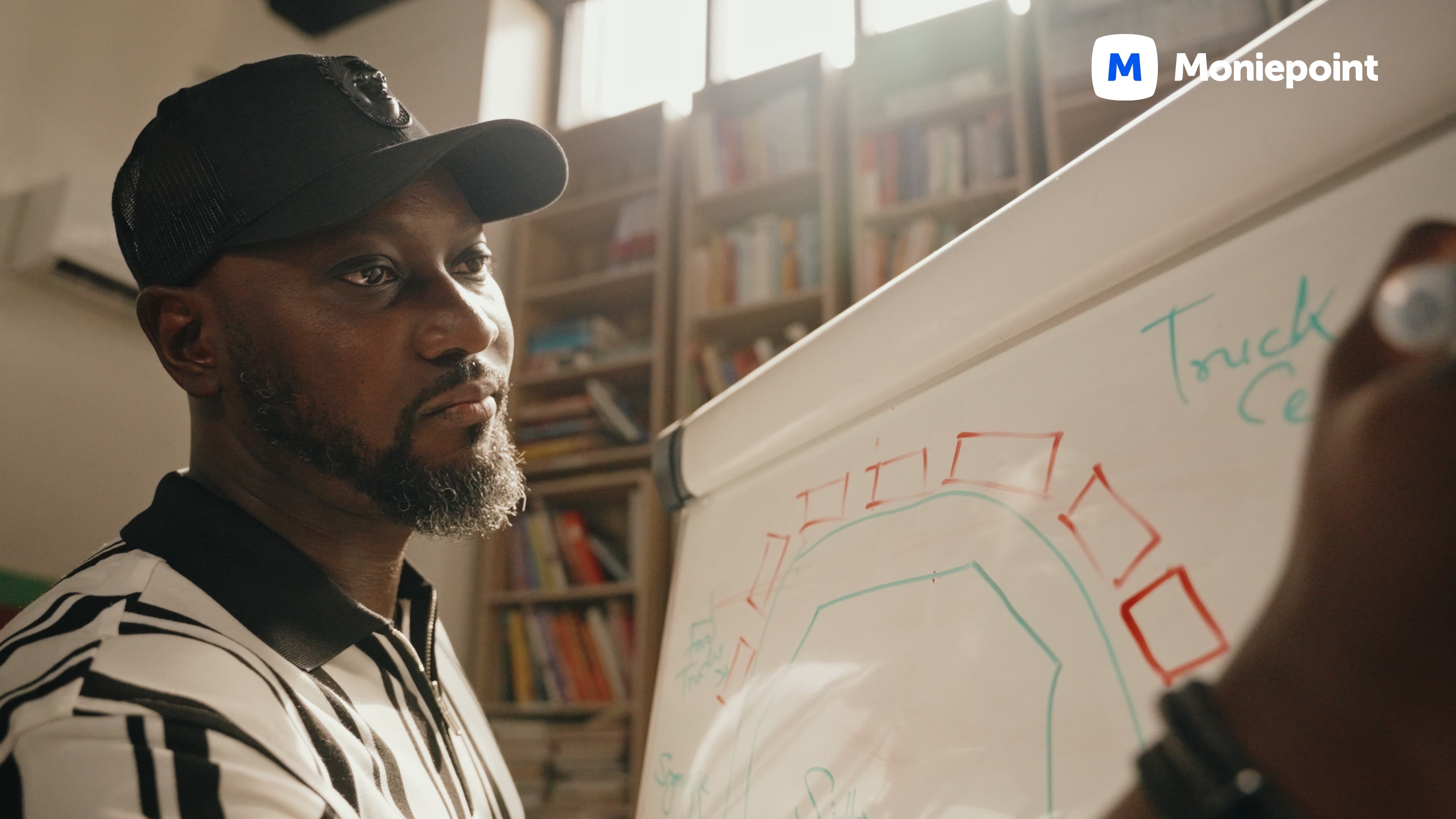 Founder mapping truck-centre logistics on a whiteboard — Moniepoint brand film.